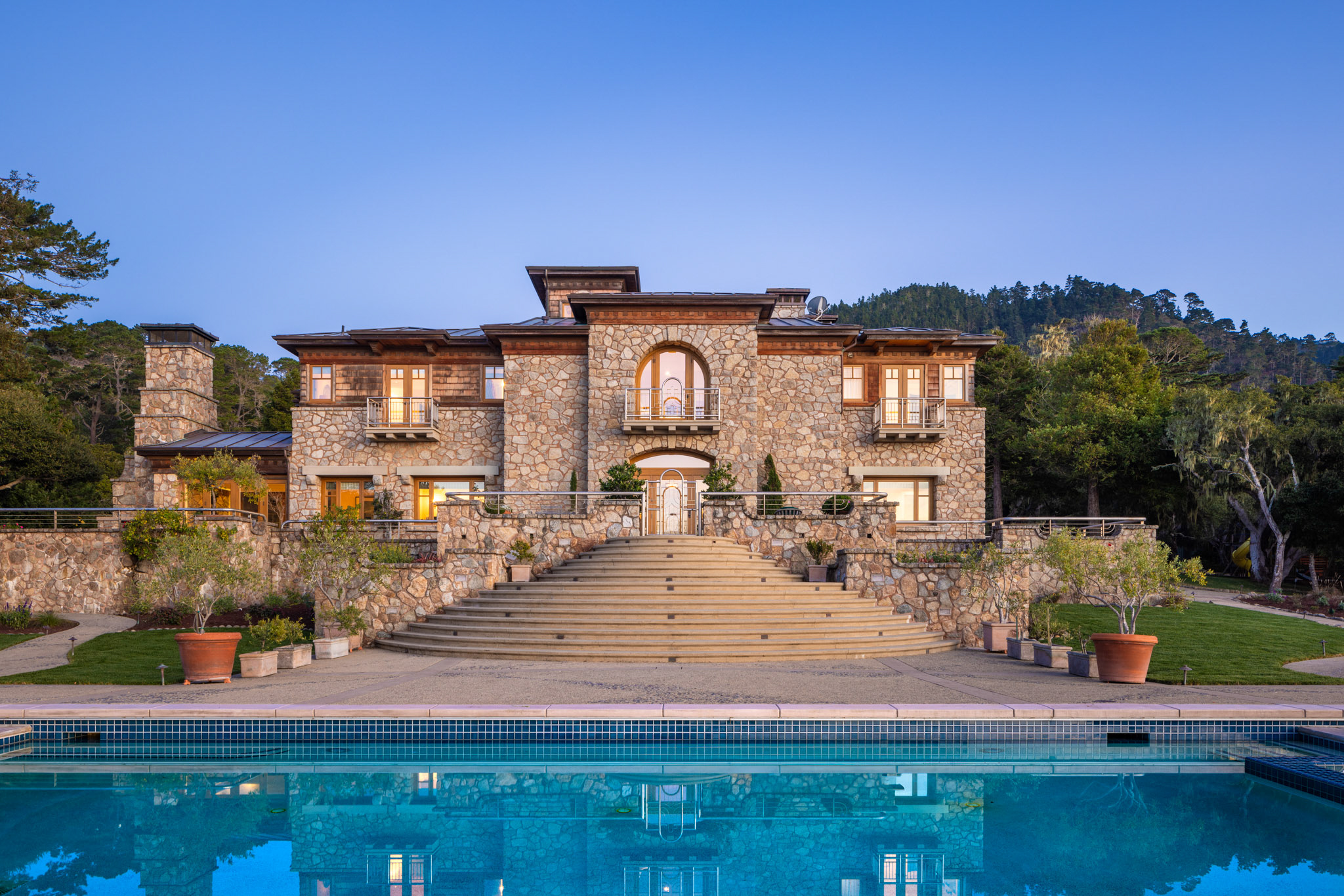 stone and wood-trimmed home with expansive rear deck and pool